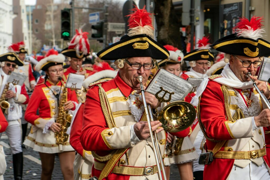 people in red and white traditional dress playing musical instruments during daytime